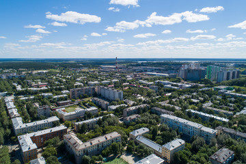 Fototapeta na wymiar Top down aerial drone image of a Ekaterinburg with low houses and new high-rise buildings. Midst of summer, backyard turf grass and trees lush green.