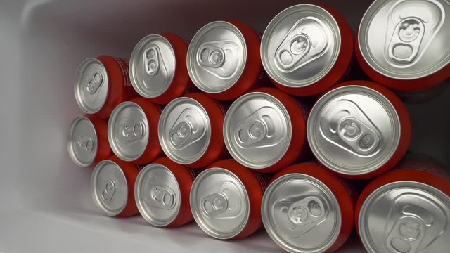 refrigerator clogged with cans of soda. aluminum cans of beverage lie in an filled fridge. Cans with beer on a shelf in the refrigerator. dolly slow motion shot close up medium