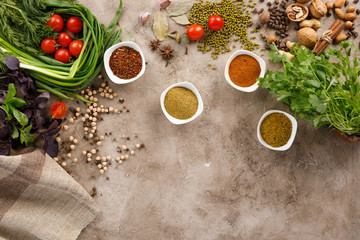 Fresh greens and tomatoes cereals spices and nuts organic healthy snacks on a textural background. The concept of healthy eating. Lean foods. Copy space.