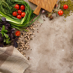 Fresh greens and tomatoes cereals spices and nuts organic healthy snacks on a textural background. The concept of healthy eating. Lean foods. Copy space.