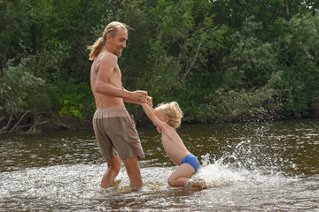 Fototapeta premium father teaching his little son to swim, they are happy.summer time. beach. sunny. vacation. holiday. family.