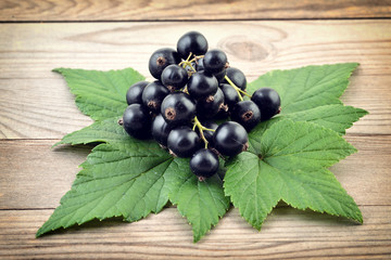 Black currant on wooden background. Black fresh berries. 