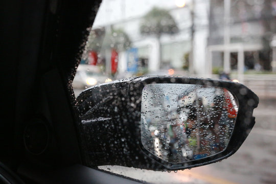Raindrops on car rear view mirror outside. © zilvergolf