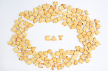 Text "EAT" at center and around from English alphabet cookie on white background.