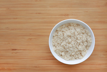 Dried shredded fish floss in white bowl on wooden board background with copy space.