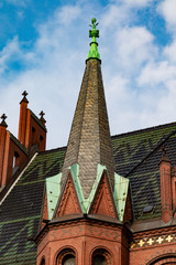 Tower of an old church builded out of red brick stones in germany under blue sky