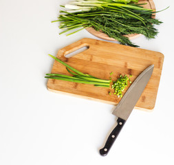  cutting board with knife and green onions on white