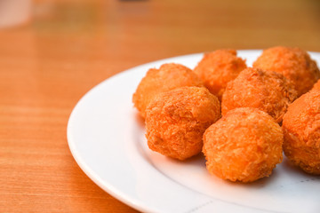 Cheese balls, Breaded mozzarella cheese balls with tomato in white dish on wood blackground