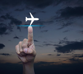 Fototapeta na wymiar Hand pressing airplane flat icon over sunset sky, Business transportation concept
