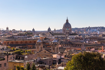 Obraz na płótnie Canvas Panoramic sight from the heights with the dome and rooftops of the eternal city in Rome, Italy