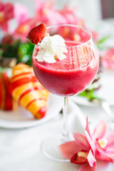 strawberry smoothie in a glass with whipped cream. healthy breakfast strawberry smoothie