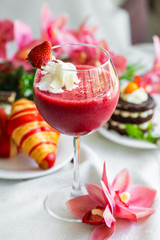 strawberry smoothie in a glass with whipped cream. healthy breakfast strawberry smoothie