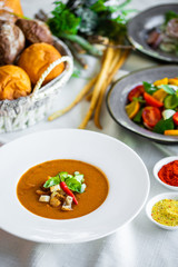 Mexican lunch, gazpacho soup with crackers and hot peppers in a white plate. tomato soup with vegetables. mexican soup. Puree soup tomato with croutons. Diet menu. tomato soup in a white plate