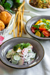 Spring vegetable salad of cucumber radishes, green onions and eggs with mayonnaise. vegetarian salad