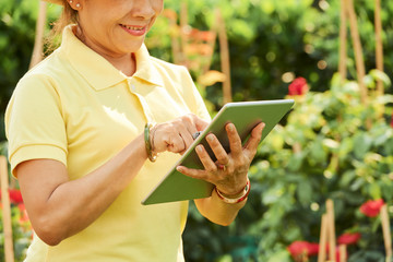 Smiling gardener with tablt computer