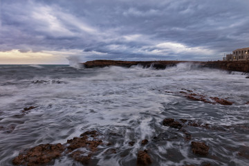 Fototapeta na wymiar Wellen schlagen gegen die Felsenküste und die Brandung rollt in die Bucht