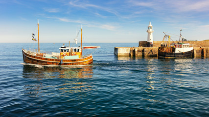 Obraz premium Ein weißer kleiner Leuchtturm an der Südküste Englands mit blauem Meer, Wolken und Booten