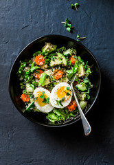 Easter brunch quinoa, eggs, avocado, cucumber, carrot salad on dark background, top view. Healthy vegetarian food concept