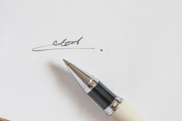 pen with signature and document in background