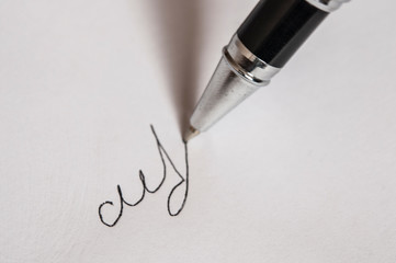 pen with signature and document in background