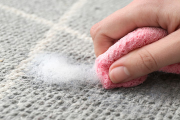 Woman cleaning carpet, closeup