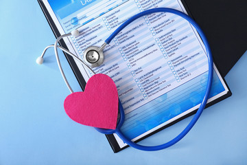 Stethoscope with laboratory test and heart on color background