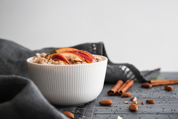 Bowl with tasty sweet oatmeal on table
