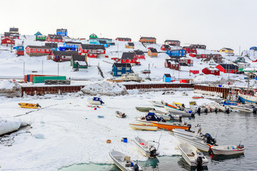 Harbor area with motorboats and colorful inuit houses in backgroung, Aasiaat city - obrazy, fototapety, plakaty
