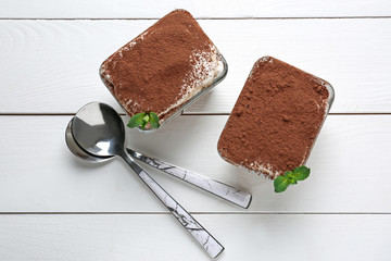 Tasty tiramisu on white wooden table