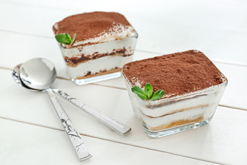 Tasty tiramisu on white wooden table
