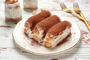 Tasty tiramisu on white wooden table