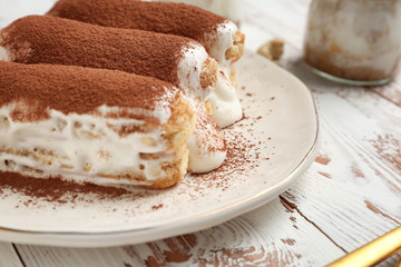 Tasty tiramisu on white wooden table