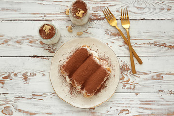 Tasty tiramisu on white wooden table