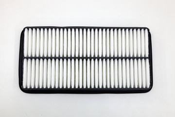 Top view on spare part for car engine air filter for cleaning dust and dirt on a white isolated background. Maintenance and oil change in auto service industry.