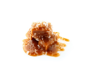 Tasty salty caramel candies on white background