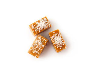 Tasty salty caramel candies on white background