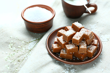 Tasty salty caramel candies on table