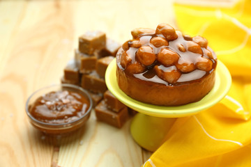 Tasty cake with caramel on wooden table