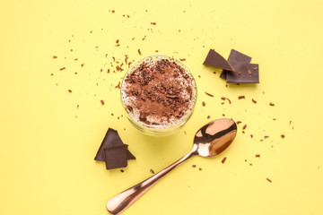 Glass with tasty tiramisu on color background
