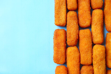Tasty mozzarella sticks on color background