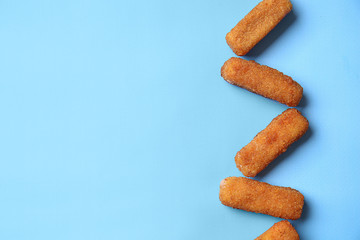 Tasty mozzarella sticks on color background