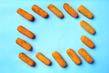 Frame made of tasty mozzarella sticks on color background