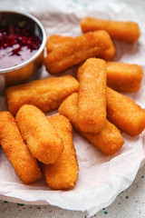 Tasty mozzarella sticks with jam on white table, closeup