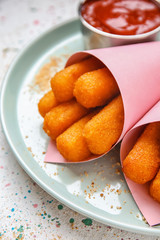 Plate with tasty mozzarella sticks on white table