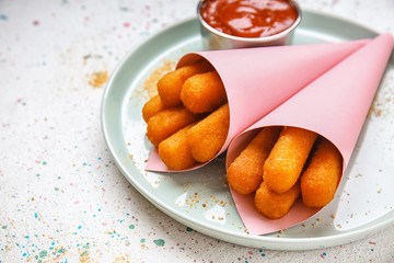 Plate with tasty mozzarella sticks on white table