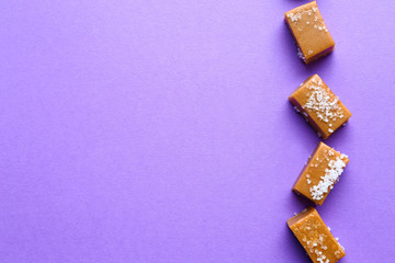 Tasty candies with salt on color background