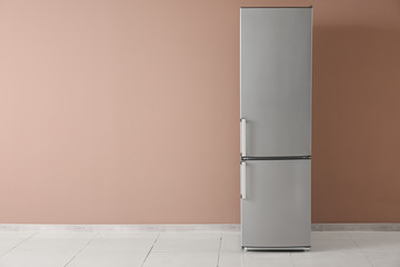 Modern fridge near color wall