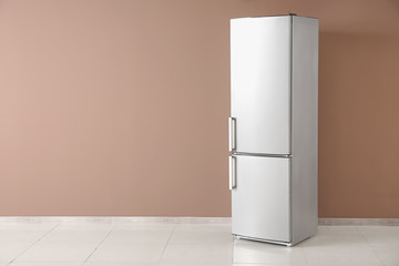 Modern fridge near color wall
