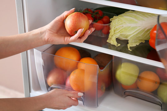 Woman Taking Apple From Fridge