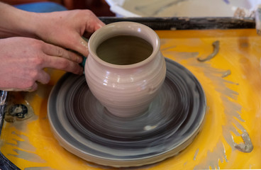 Master class on making a ceramic pot with a Potter's wheel. The pottery is rotating around its axis.